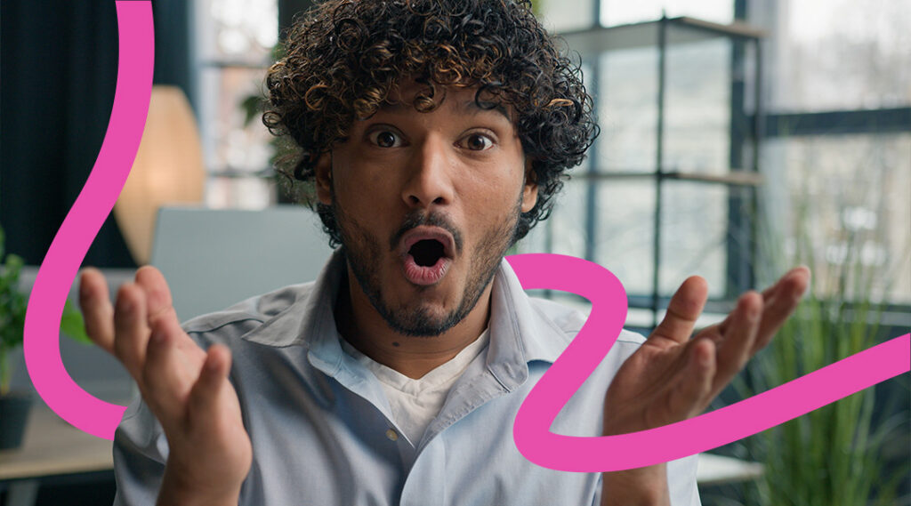 A surprised man with curly hair in an office, mouth open, with pink abstract curves overlaying the scene.